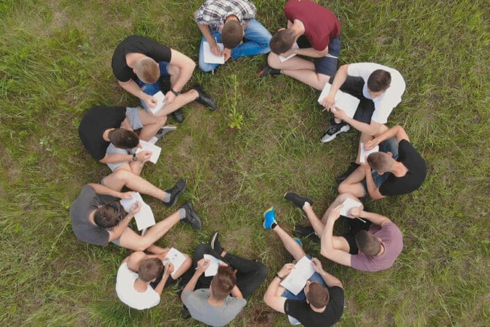 group of students sitting on grass studying team work field trip group of students sitting on grass studying team work field trip