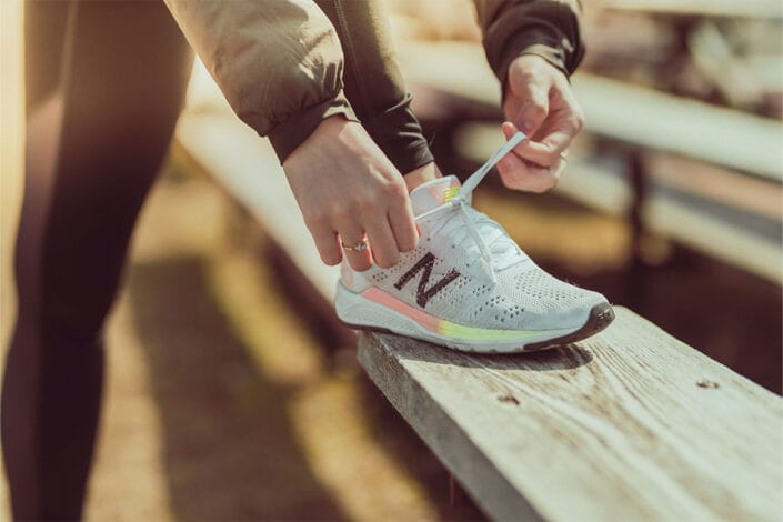 student tying sports shoe laces bench sports field or track student tying sports shoe laces bench sports field or track