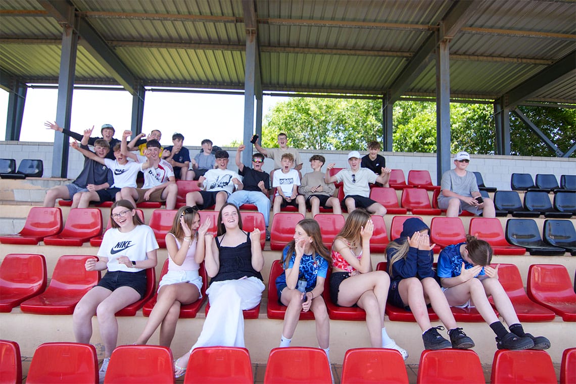 students watching a football game from the stands