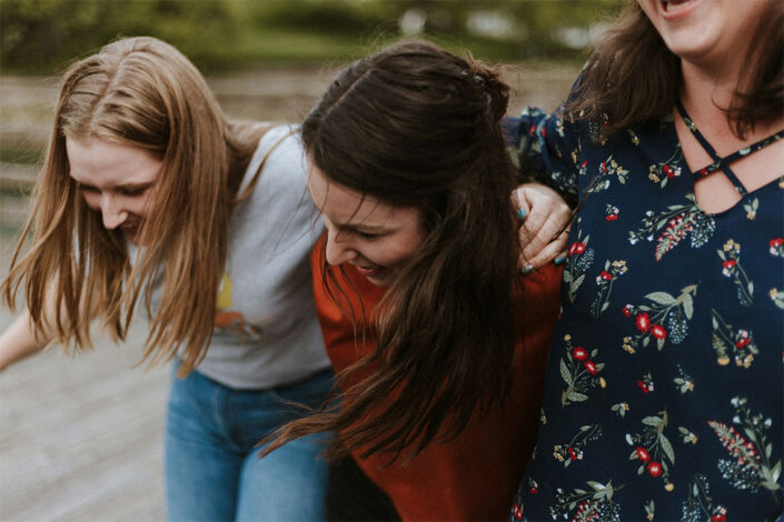 three students smiling outdoors three students smiling outdoors
